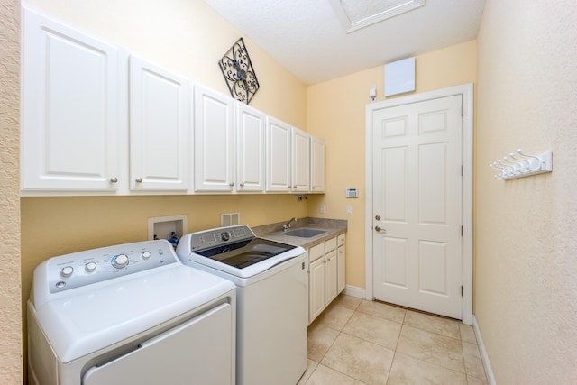 clothes washing area with cabinet space, separate washer and dryer, baseboards, and light tile patterned floors