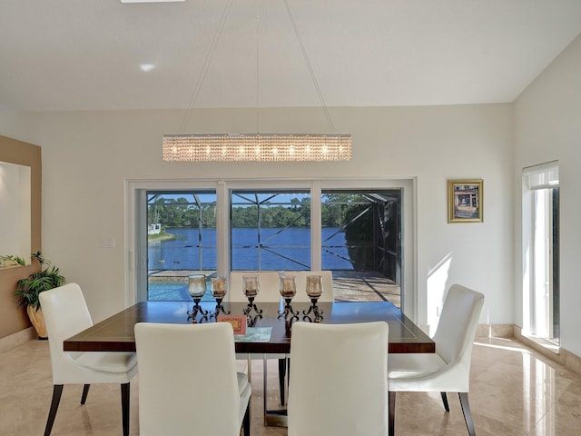 dining room featuring healthy amount of natural light, a water view, and a chandelier