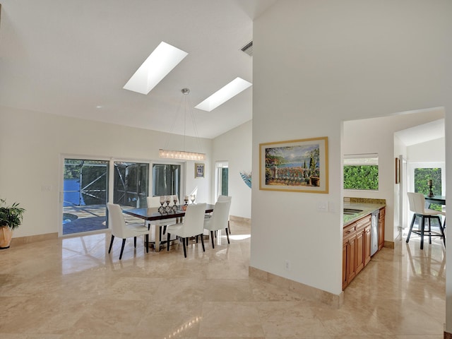 dining area featuring a skylight, high vaulted ceiling, baseboards, and light marble finish flooring