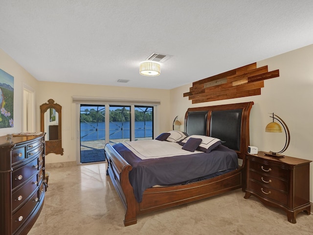 bedroom featuring access to exterior and a textured ceiling