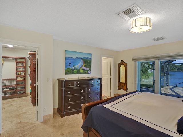 bedroom with access to exterior and a textured ceiling