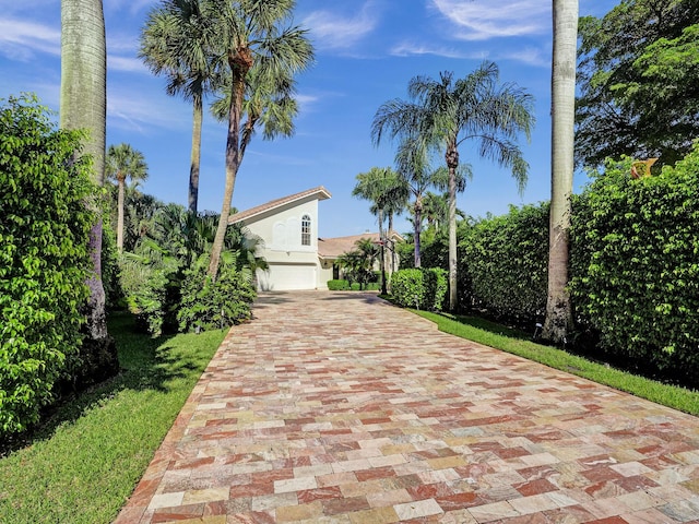 view of front facade with a garage, decorative driveway, and stucco siding