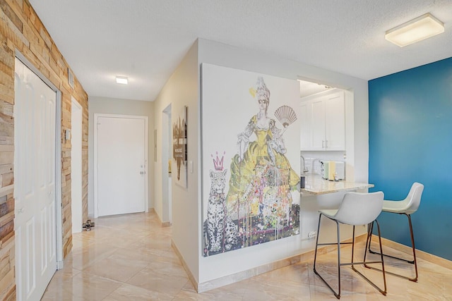 2724 N Garden Dr Unit 302, Lake Worth, FL 33461 - hallway with light marble finish floors, baseboards, and a textured ceiling