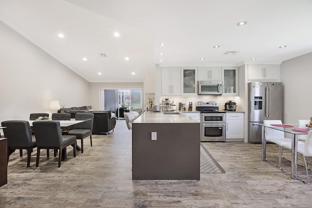 kitchen featuring stainless steel appliances, white cabinets, light wood-style floors, and recessed lighting