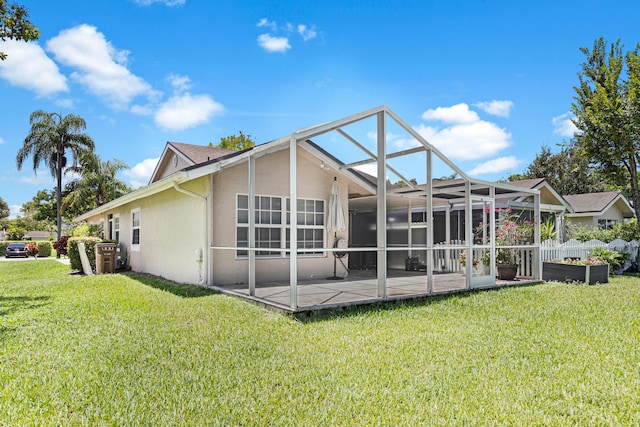 rear view of property with stucco siding, a patio area, a lawn, and a lanai