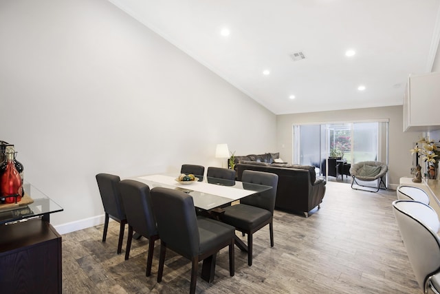 dining space featuring light wood finished floors, recessed lighting, lofted ceiling, baseboards, and ornamental molding