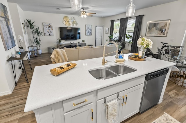 kitchen featuring a sink, stainless steel dishwasher, ceiling fan, open floor plan, and white cabinetry