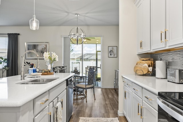 kitchen with a chandelier, a sink, stainless steel dishwasher, wood finished floors, and light countertops