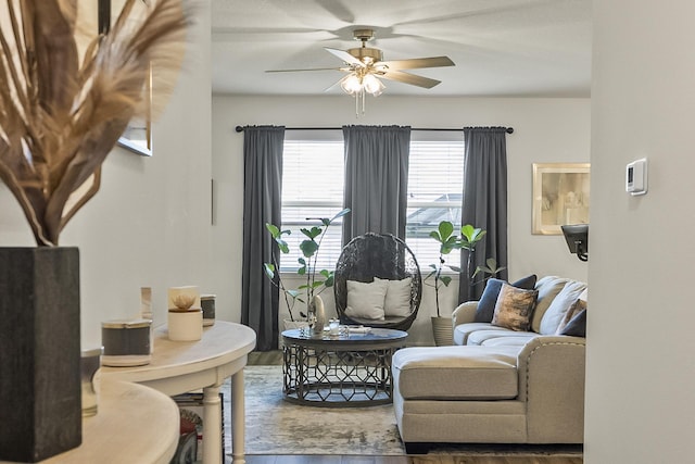 living area with wood finished floors and a ceiling fan