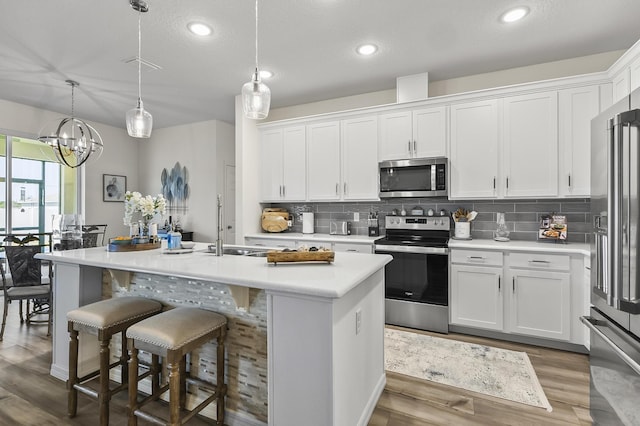 kitchen featuring stainless steel appliances, light countertops, white cabinetry, backsplash, and recessed lighting