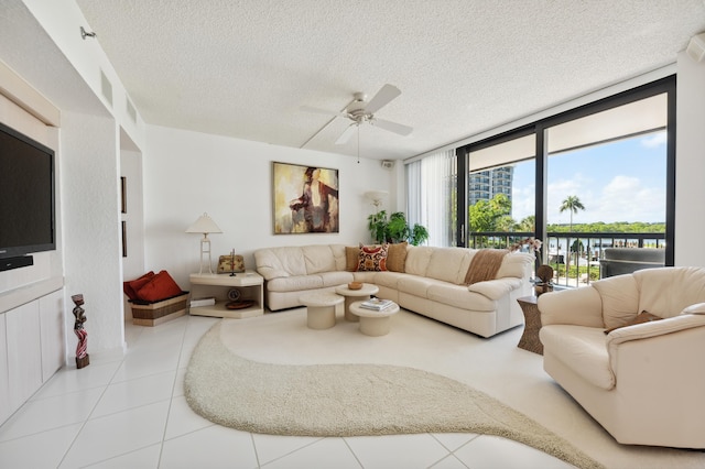 tiled living area featuring a textured ceiling, a ceiling fan, and expansive windows