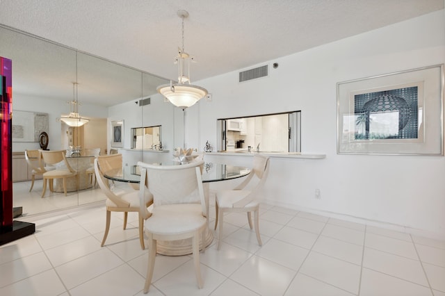 dining space featuring a textured ceiling and tile patterned flooring