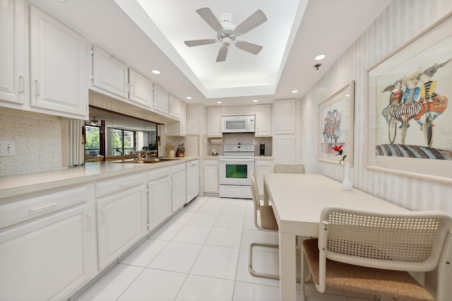 kitchen featuring white appliances, a sink, ceiling fan, light tile patterned floors, and white cabinetry