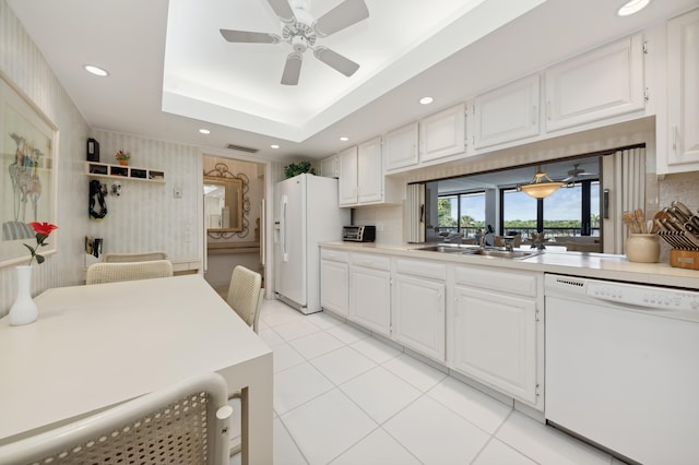 kitchen featuring white appliances, a sink, a ceiling fan, light countertops, and white cabinetry