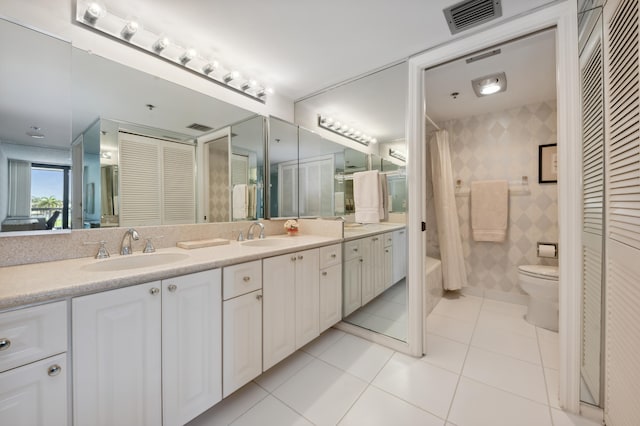 bathroom featuring a closet, tile patterned floors, double vanity, toilet, and shower / bath combo with shower curtain
