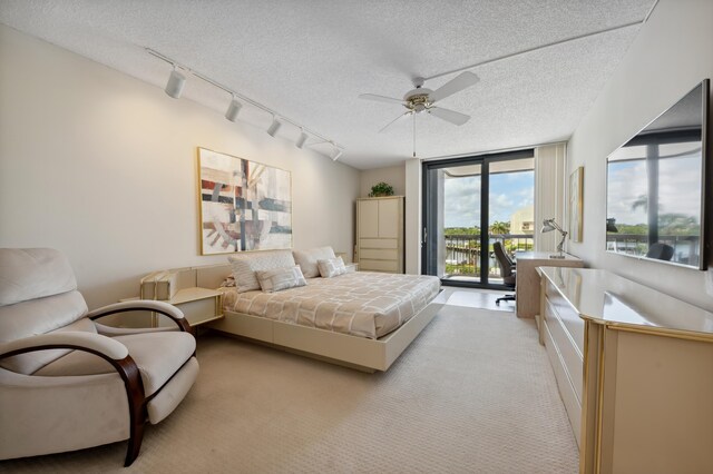 bedroom with light colored carpet, access to outside, track lighting, a textured ceiling, and a ceiling fan