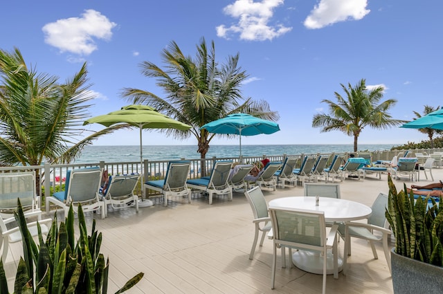 view of patio / terrace with a deck with water view and outdoor dining area