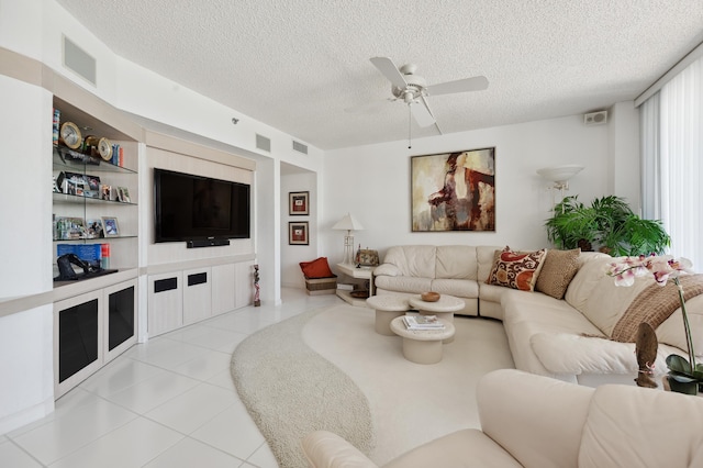 living area featuring ceiling fan, a textured ceiling, and tile patterned floors
