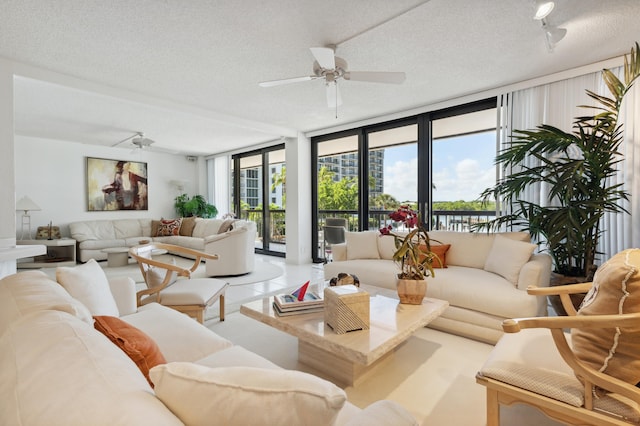 living room with expansive windows, a textured ceiling, a ceiling fan, and healthy amount of natural light