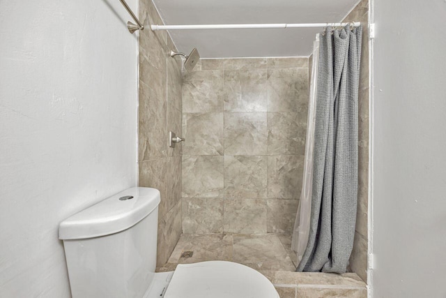 bathroom featuring toilet and tiled shower