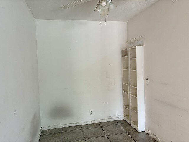 spare room with a ceiling fan and tile patterned floors