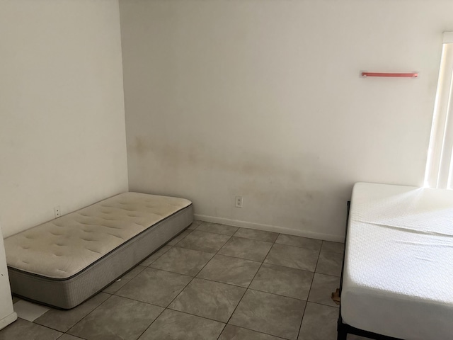 bedroom featuring tile patterned flooring and baseboards