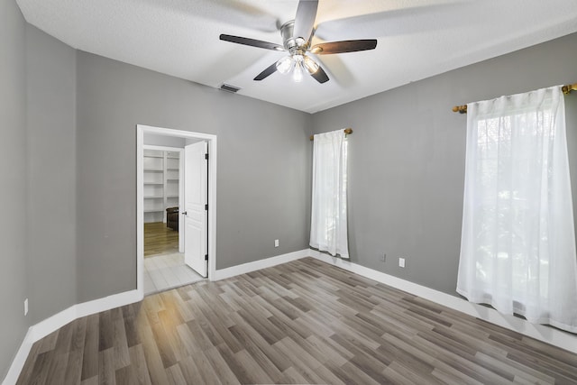 4841 Glenn Pine Ln, Boynton Beach, FL 33436 - unfurnished bedroom featuring wood finished floors, a spacious closet, baseboards, and a ceiling fan