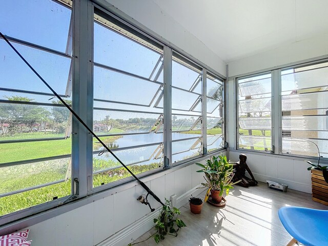 sunroom / solarium featuring a water view and healthy amount of natural light