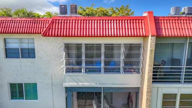 view of side of home featuring stucco siding and central AC