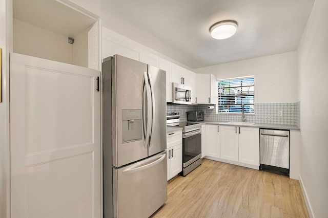320 Norwood Ter Unit N114, Boca Raton, FL 33431 - kitchen featuring stainless steel appliances, light wood finished floors, white cabinetry, and decorative backsplash