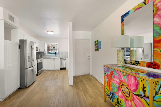 320 Norwood Ter Unit N114, Boca Raton, FL 33431 - kitchen featuring stainless steel appliances, light wood-style floors, white cabinetry, tasteful backsplash, and baseboards