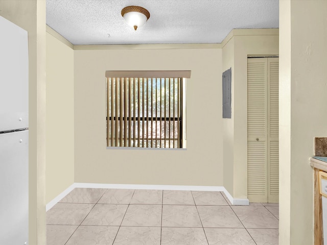 unfurnished room featuring a textured ceiling, baseboards, and electric panel