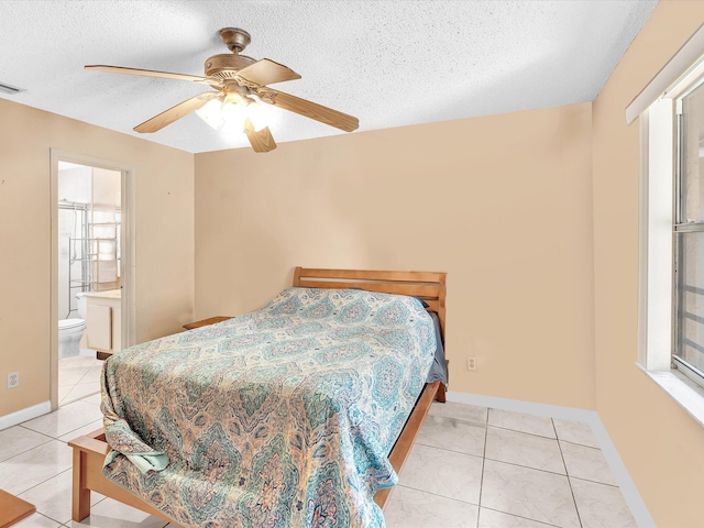 bedroom with light tile patterned floors, a textured ceiling, baseboards, ceiling fan, and ensuite bathroom