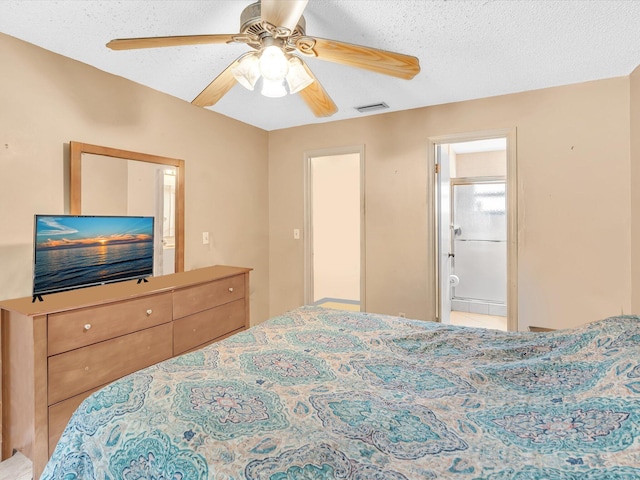 bedroom with a ceiling fan, ensuite bath, and a textured ceiling