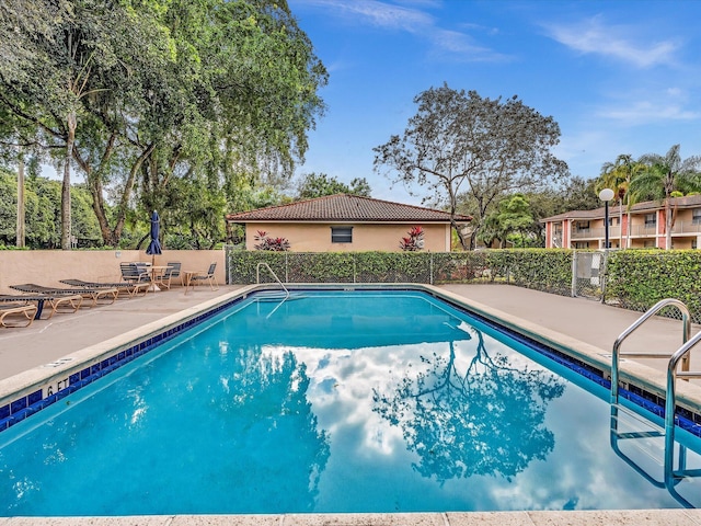 community pool featuring a patio area and fence