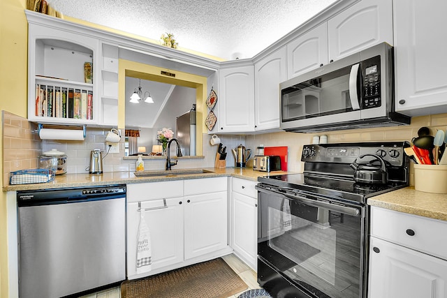 3171 SE Aster Ln Unit 1107, Stuart, FL 34994 - kitchen featuring appliances with stainless steel finishes, a sink, backsplash, white cabinets, and a textured ceiling