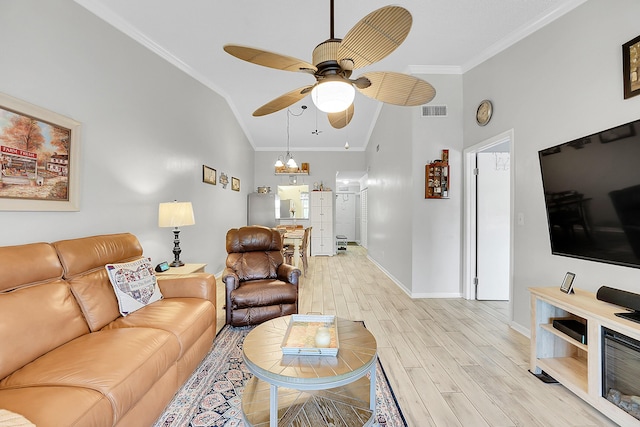living area with vaulted ceiling, ceiling fan, ornamental molding, light wood-type flooring, and baseboards