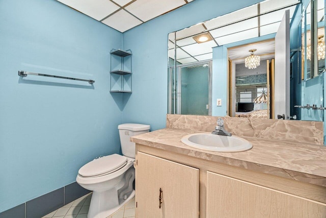 bathroom with toilet, a shower stall, vanity, a chandelier, and tile patterned floors