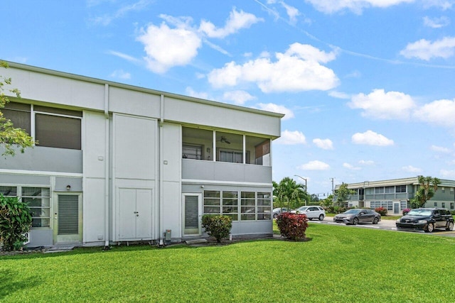 rear view of house with a yard and uncovered parking