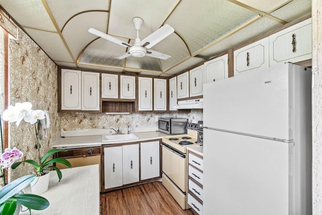 kitchen featuring white appliances, under cabinet range hood, a sink, light wood-type flooring, and a ceiling fan