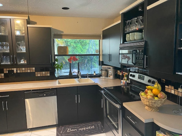 7514 Sierra Dr E, Boca Raton, FL 33433 - kitchen featuring stainless steel appliances, dark cabinets, a sink, light countertops, and a textured ceiling
