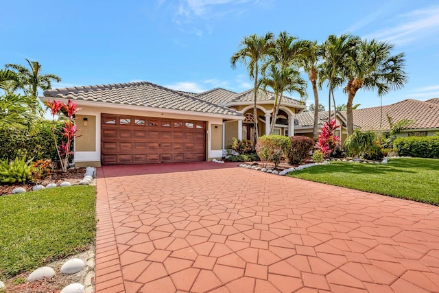 19236 Bay Leaf Ct, Boca Raton, FL 33498 - mediterranean / spanish home with an attached garage, a front yard, decorative driveway, a tiled roof, and stucco siding