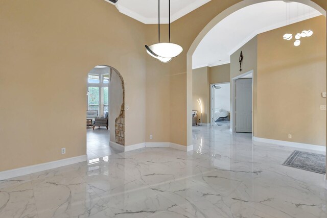 19236 Bay Leaf Ct, Boca Raton, FL 33498 - unfurnished room with arched walkways, crown molding, light marble finish floors, a towering ceiling, and baseboards