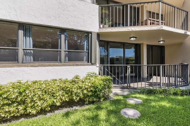 entrance to property featuring stucco siding and a balcony