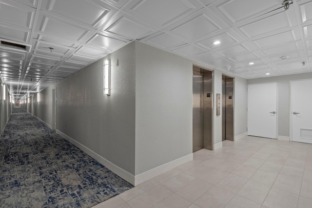 hall featuring elevator, baseboards, and recessed lighting