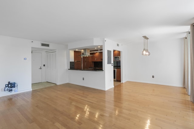 unfurnished living room with light wood-style flooring and baseboards