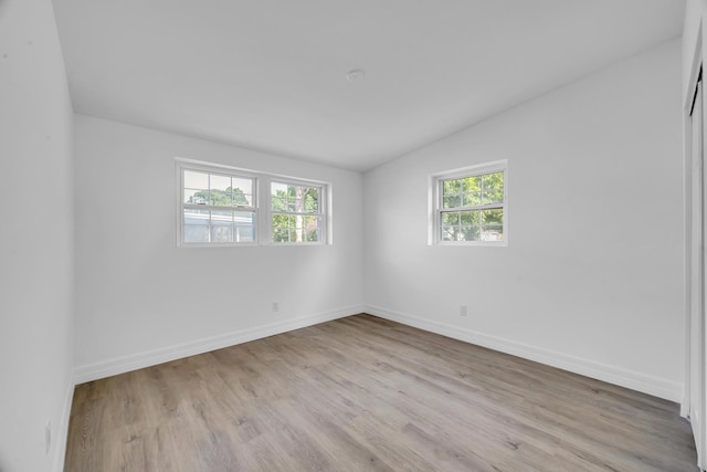 907 Skylark Dr, Fort Pierce, FL 34982 - spare room with wood finished floors, vaulted ceiling, and baseboards