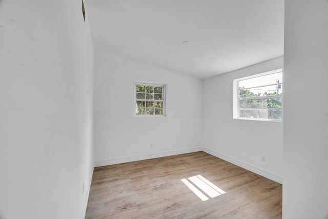 907 Skylark Dr, Fort Pierce, FL 34982 - empty room with healthy amount of natural light, wood finished floors, baseboards, and vaulted ceiling