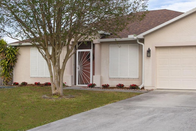 doorway to property with stucco siding, an attached garage, a yard, and a shingled roof