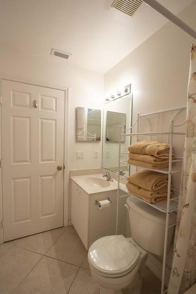 bathroom with toilet, tile patterned flooring, and vanity